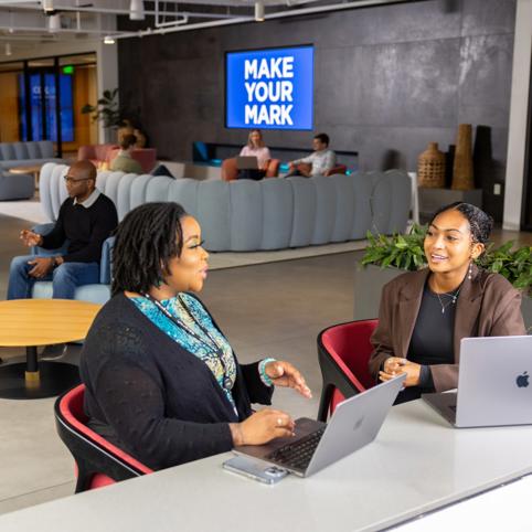 a group of Cox employees sitting in chairs and using laptops
