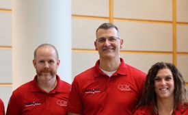 a group of Cox Veterans wearing red polo shirts