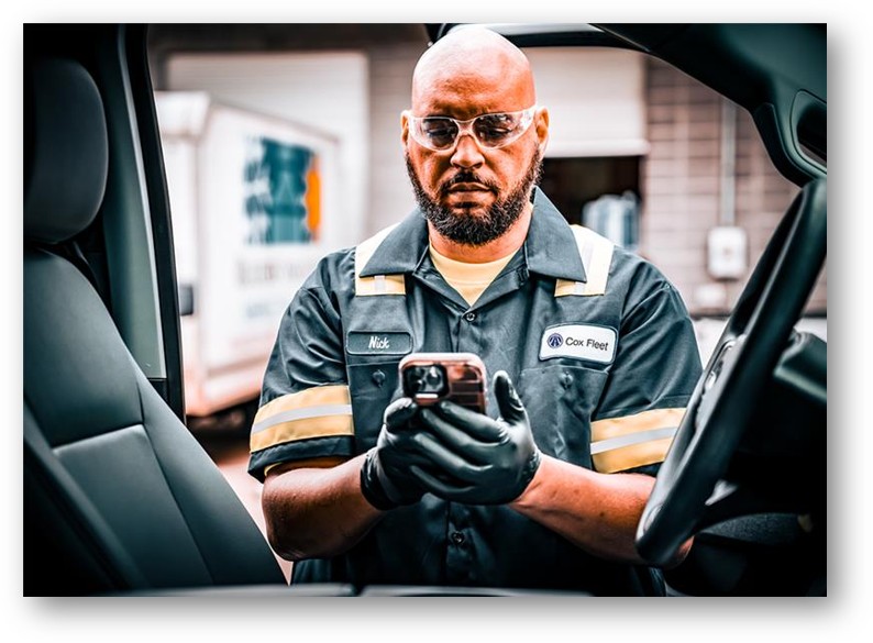 a person in a uniform and glasses looking at a cellphone