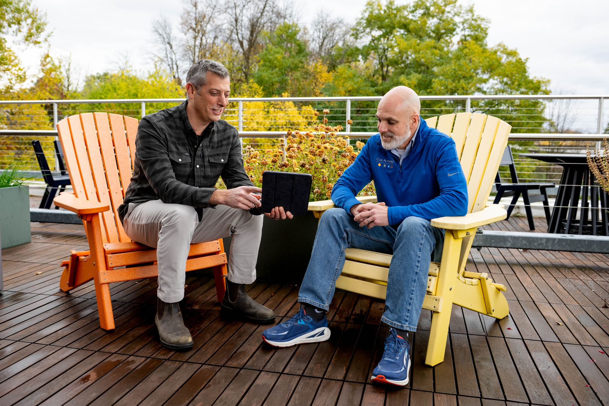 two men sitting on a deck