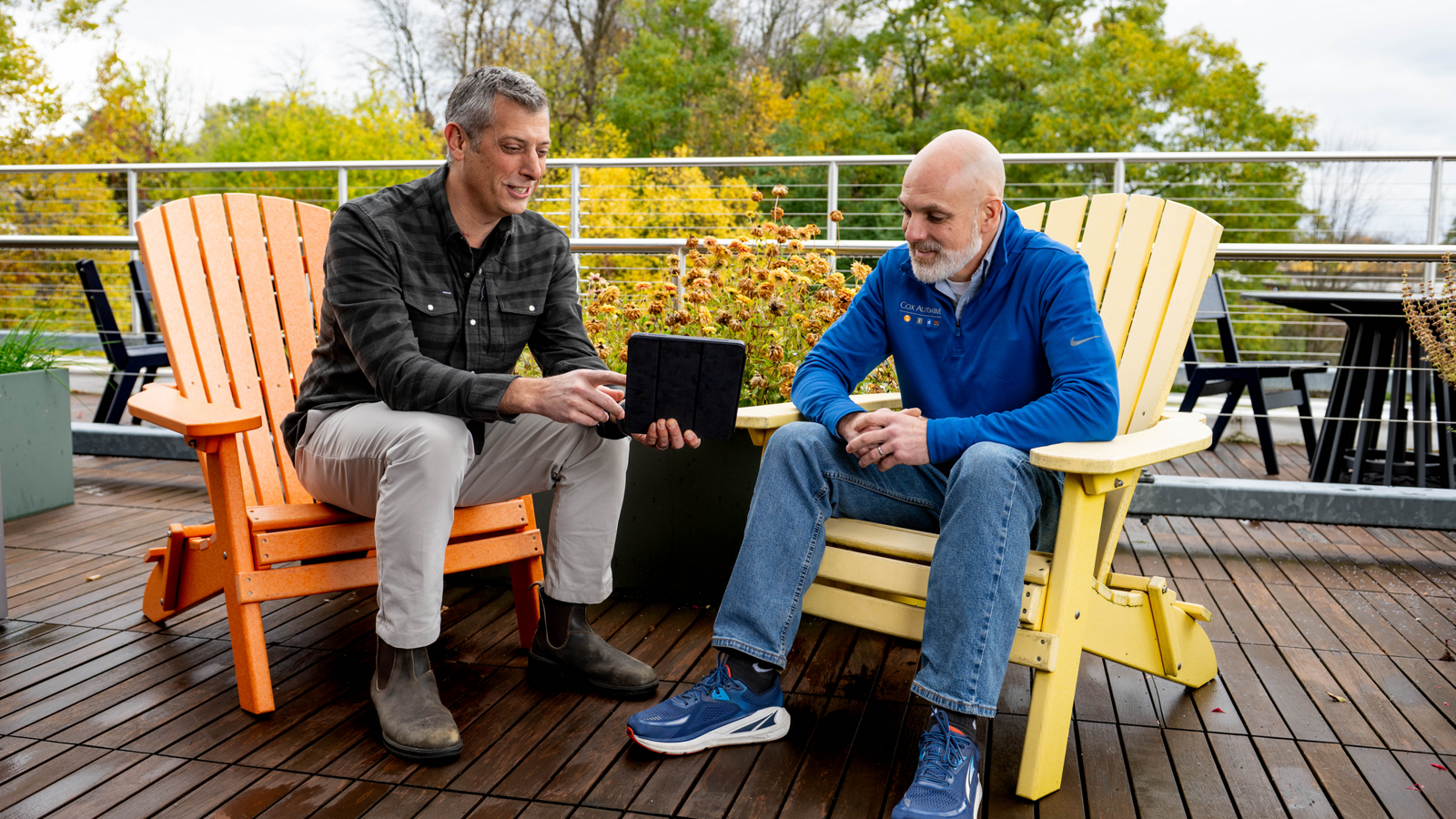 two men sitting on a deck
