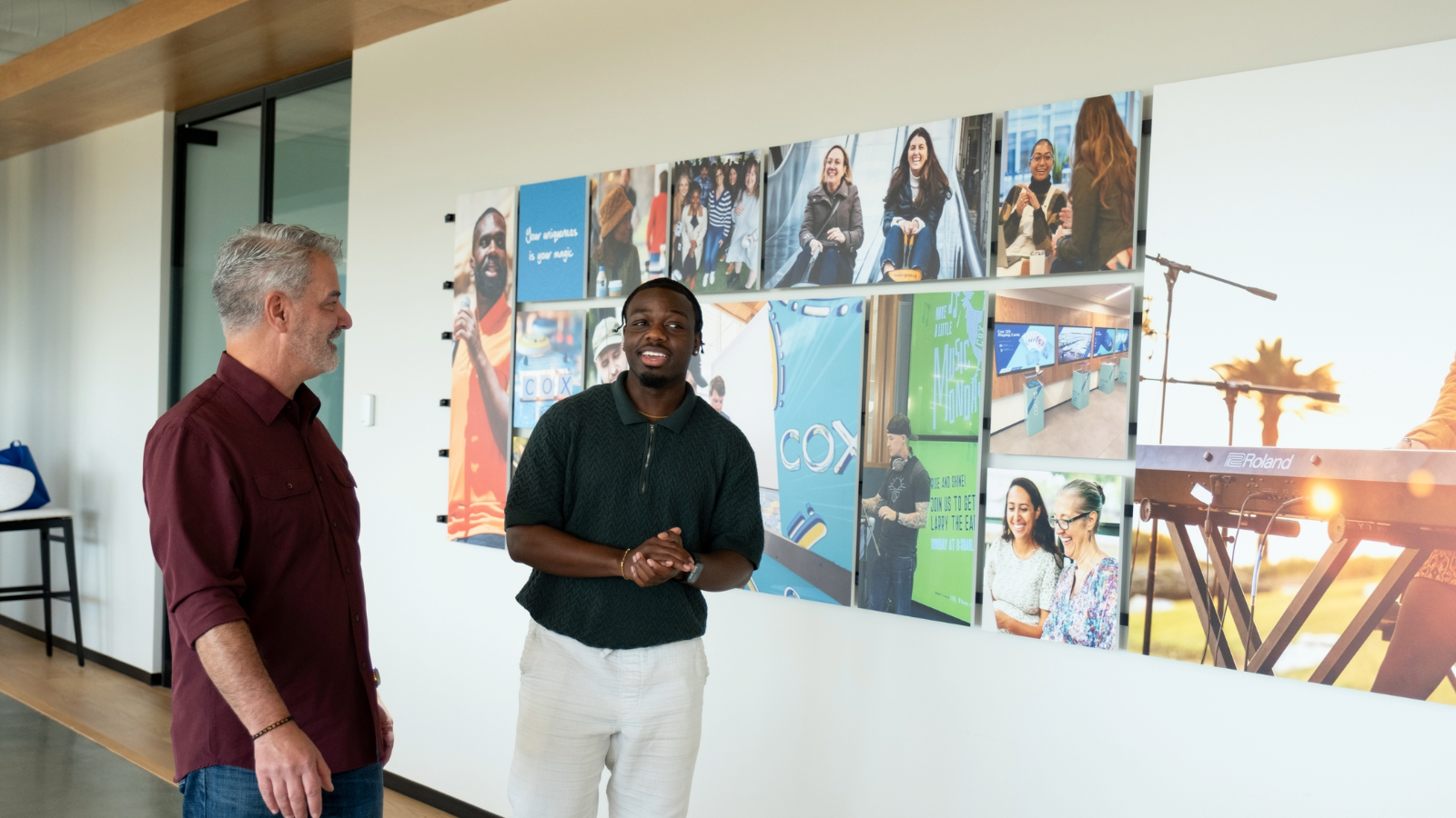 a person and a person standing in front of a wall of pictures