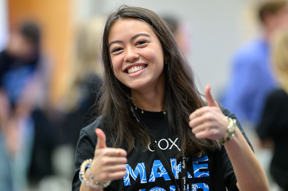 a person smiling with thumbs up