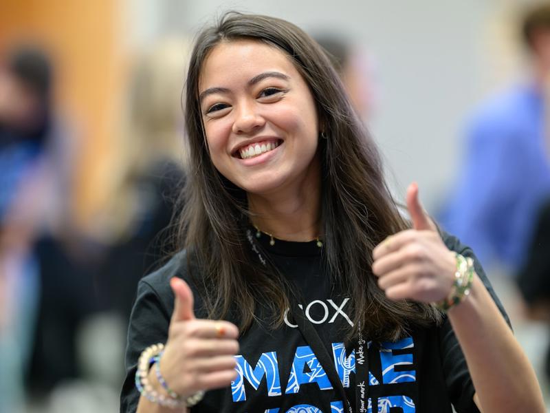 a person smiling with thumbs up