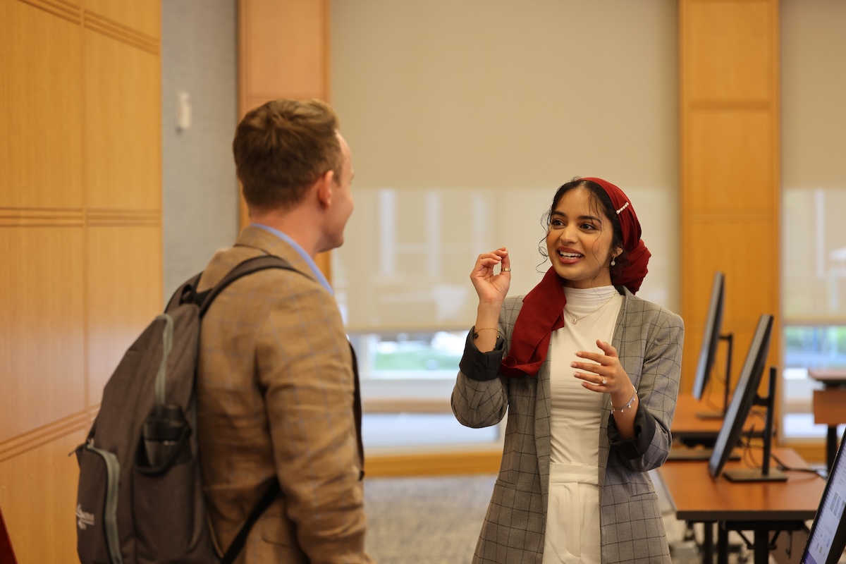 a person in a red scarf talking to a person in a room