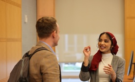 a person in a red scarf talking to a person in a room