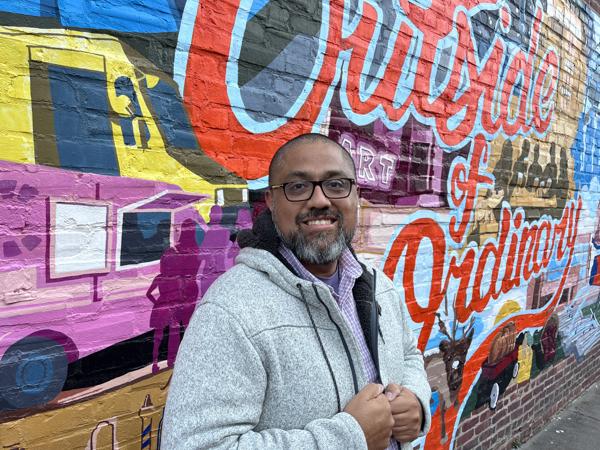 Gustavo Velazque Cox employee headshot in front of mural