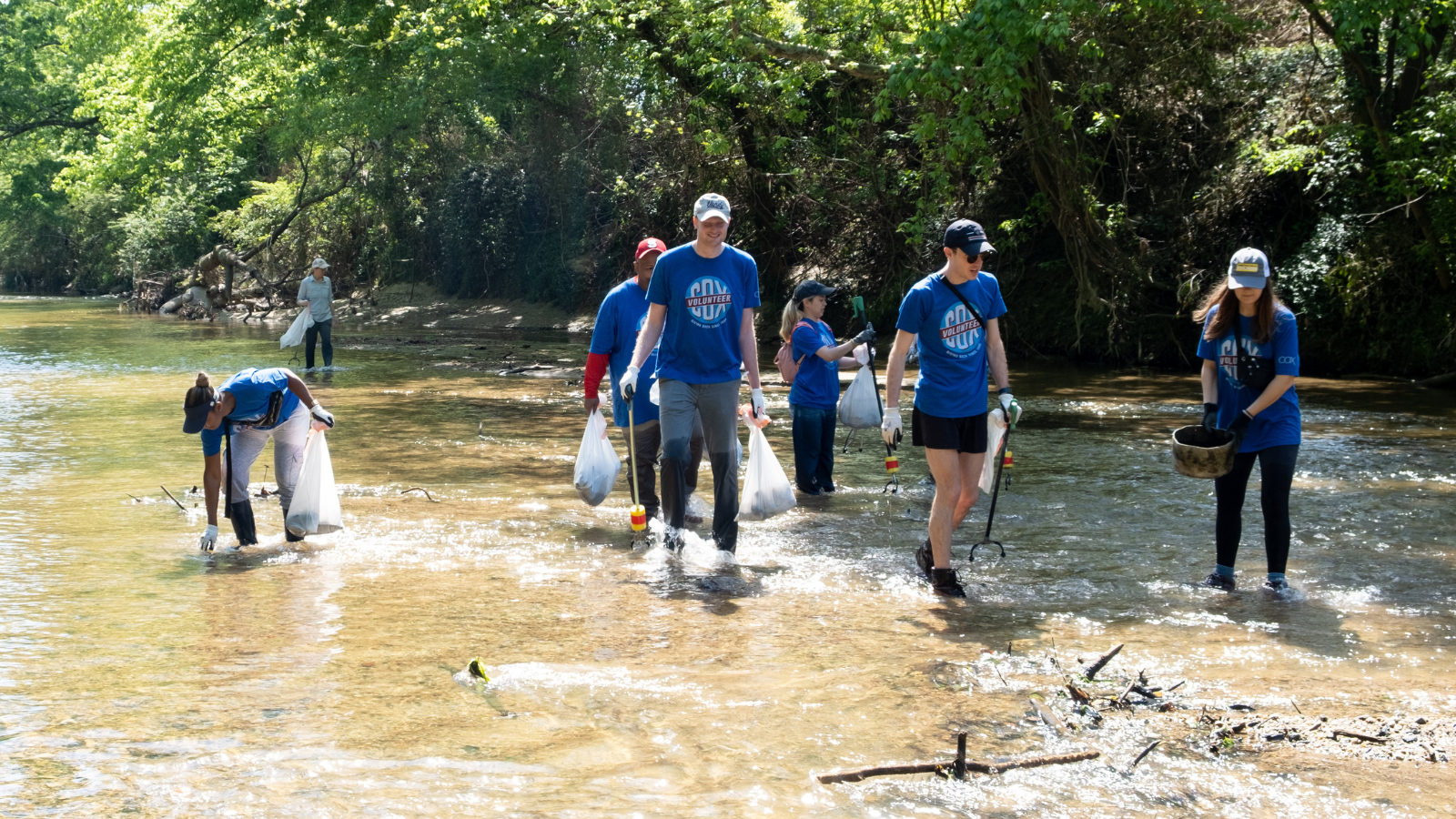 Cox employees cleaning up a river