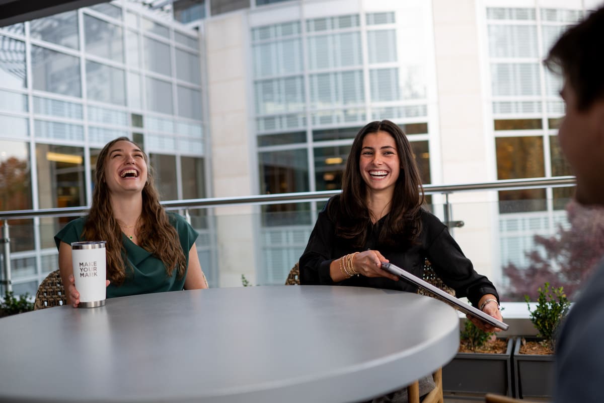 two women laughing at a table