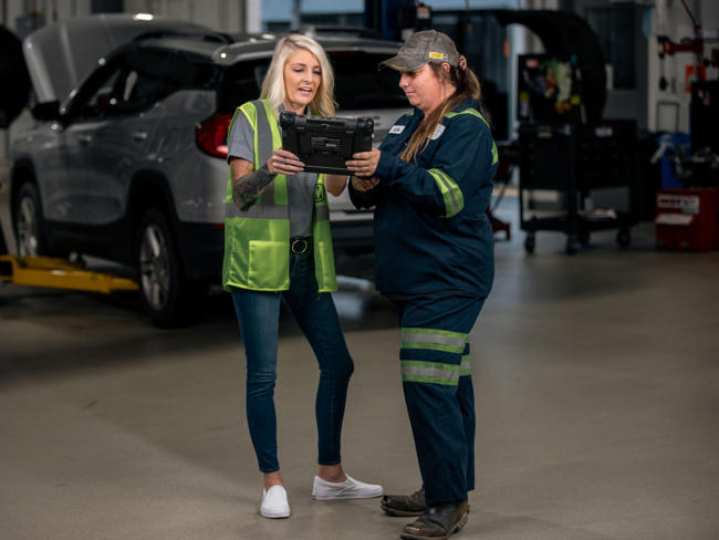 Cox Automotive technicians on a tablet