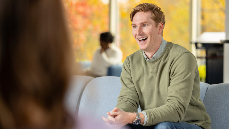 a person sitting on a couch smiling