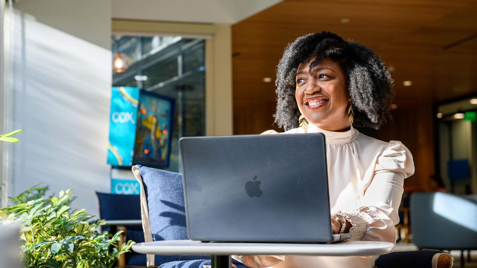 a person sitting at a table with a laptop