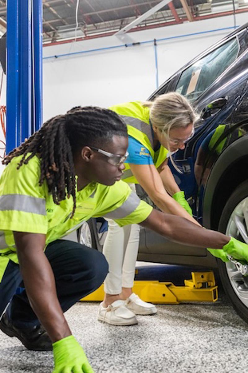 a person and a person working on a car