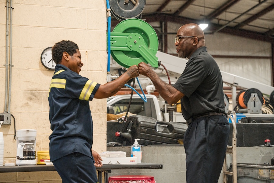 a person holding a green object with another person in the background