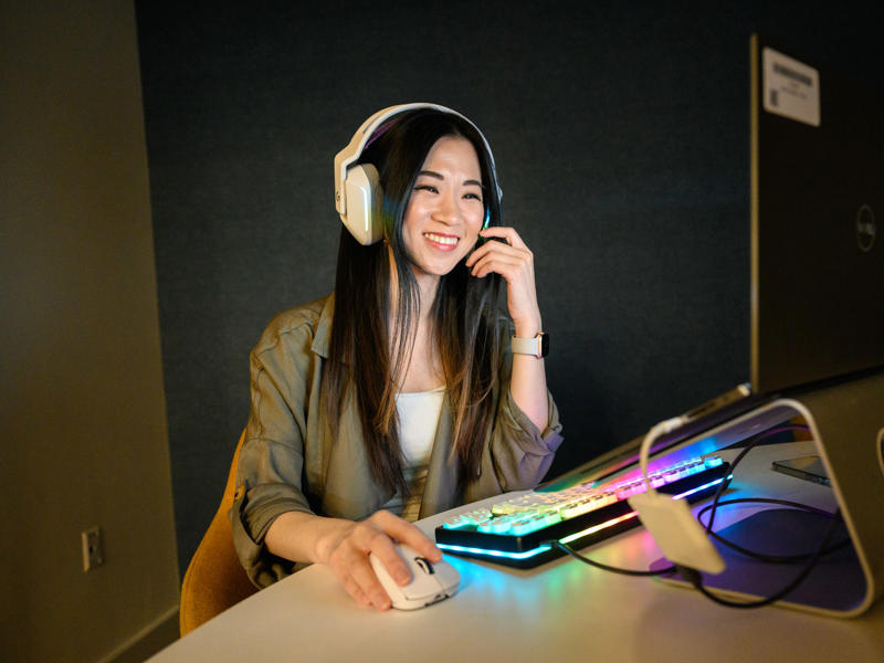 a Cox employee wearing headphones and sitting at a desk with a computer