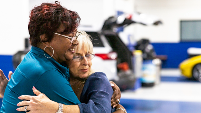 two Cox employees embracing